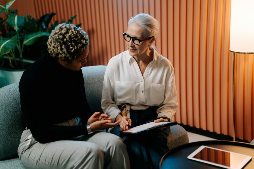 pexels-photo-5989928-5989928 Two professional women engaged in a business discussion indoors with documents.