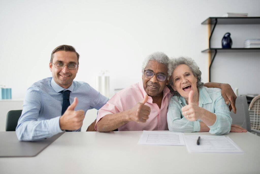 pexels-photo-8441870-8441870 Elderly couple with consultant giving thumbs up in an office setting, showcasing positive interaction.